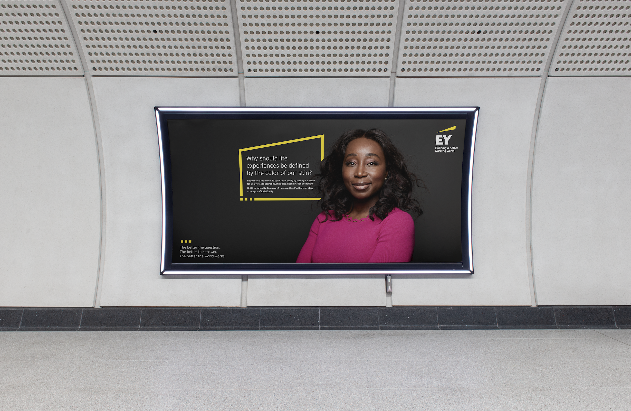 A tube tunnel billboard of EY poster with smiling black women and yellow box with text